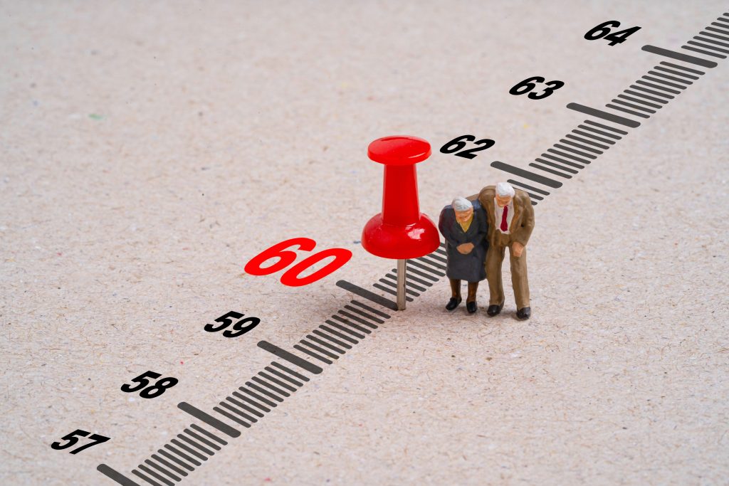 תמונת רקע למאמר כל השאלות ותשובות לתיקון 190 - תמונת אילוסטרציה של זוג קשישים מיניאטורים שעומדים ליד סרגל המדגיש את הספרות 60